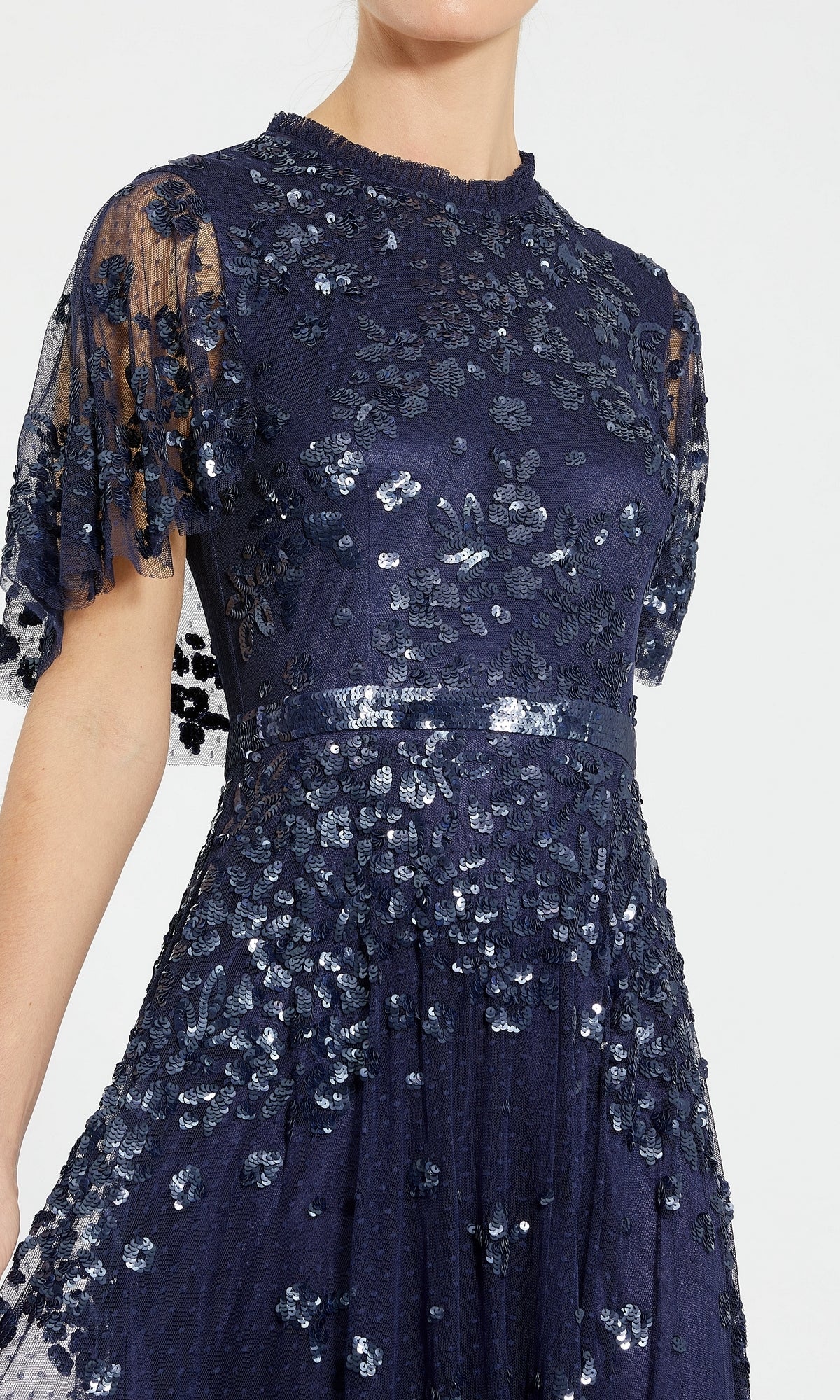 A woman wearing the Mac Duggal 9192 Short-Sleeve Blue Formal Dress, featuring sheer sleeves and elegant floral sequin embellishments.
